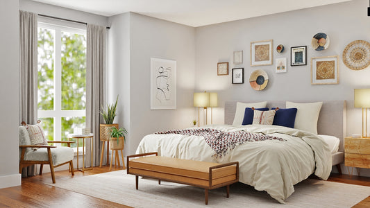 A bedroom with a bed, a leather bench, and wall art in a sunlit room