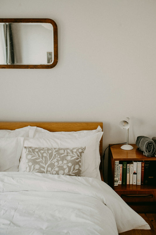 A cozy bedroom with a wooden bed and nightstand.